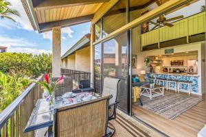 a patio with a table and chairs on a balcony at Perch - Luana Kai Loft C308 in Kihei