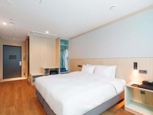 a large white bed in a hotel room at ibis Styles Ambassador Jeonju City Centre in Jeonju
