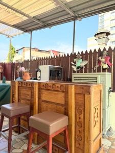 een keuken met een aanrecht met een magnetron en stoelen bij Cozy Studio Apartment Maculusso, Luanda in Luanda