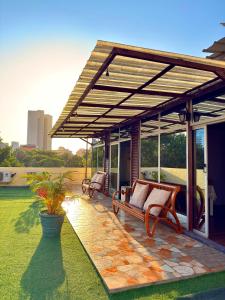 a pergola with a bench on a patio at Cozy Studio Apartment Maculusso, Luanda in Luanda