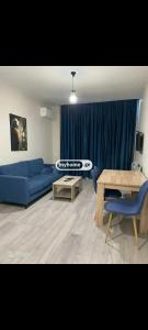 un salon avec un canapé bleu et une table dans l'établissement komuna looksi, à Kakhaberi 2 autres photos