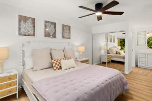 a bedroom with a white bed and a ceiling fan at Modern Princeville 1 bedroom, AC, King Bed, Hanalei in Princeville +12 photos
