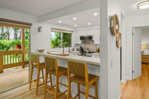 a kitchen with a island with chairs and a counter top at Modern Princeville 1 bedroom, AC, King Bed, Hanalei in Princeville
