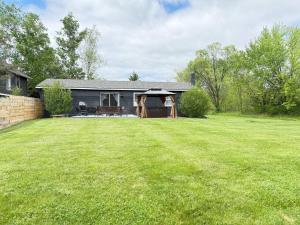 a house with a lawn in front of it at Vibing Hudson Retreat Pet-Friendly w Hot Tub in Hudson