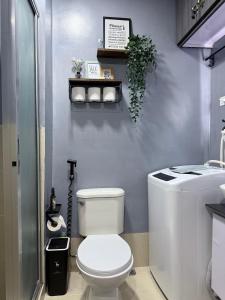 ein Badezimmer mit weißer Toilette und Waschbecken in der Unterkunft JA2 STAYCATION @TREES RESIDENCES in Manila