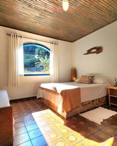 a bedroom with a large bed and a window at Hospedaria Flor da Montanha in Lumiar +24 photos