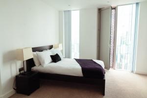 een slaapkamer met een bed en een groot raam bij Luxury 2 Bed apartment Deansgate in Manchester