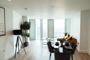 een woonkamer met een tafel en stoelen bij Luxury 2 Bed apartment Deansgate in Manchester