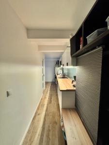 a kitchen with white walls and a wooden floor at Coliving Marais in Paris +15 photos