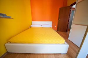 un letto in una camera con pareti arancioni e gialle di Apartment May a Mali Lošinj (Lussinpiccolo)