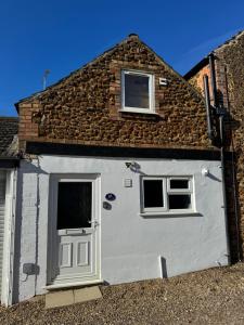 ein Haus mit einer weißen Tür und zwei Fenstern in der Unterkunft Sunset Cottage in Hunstanton