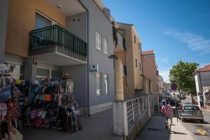 a person walking down a sidewalk next to a building at Apartment May in Mali Lošinj