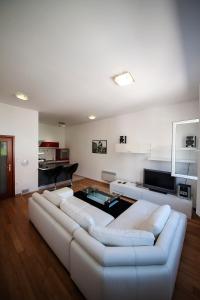 a living room with two white couches and a piano at Apartment May in Mali Lošinj