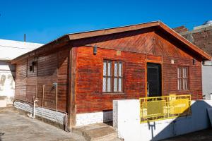 a small wooden building with a yellow door at Tu refugio en Caleta Olivia in Caleta Olivia