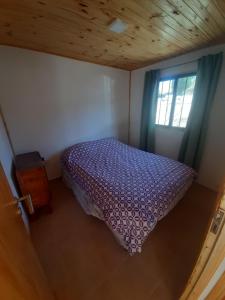 a bedroom with a purple bed and a window at Cabañas Pie del Plata in Mendoza