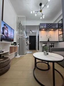 ein Wohnzimmer mit Tisch und Fernseher in der Unterkunft JA2 STAYCATION @TREES RESIDENCES in Manila
