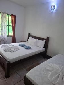 a bedroom with a bed with two towels on it at Cabinas Tortuguero Natural in Tortuguero