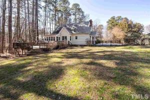 a white house with a fence in a yard at Knight play Golf court house in Apex