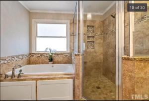 a bathroom with a tub and a shower with a window at Knight play Golf court house in Apex +60 photos