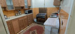 a small kitchen with a stove and a refrigerator at ABo ZAIN HOSTEL in Aswan +38 photos