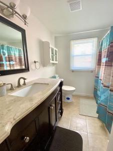 a bathroom with a sink and a toilet and a mirror at Lbi Vacation Rental Property in Beach Haven