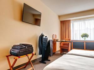 Una habitación de hotel con una maleta y un escritorio. en Standard room in Antwerp near Grand Palace, en Amberes