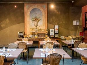 a dining room with tables and chairs and a painting on the wall at Deluxe apartment with wifi in Antwerp in Antwerp