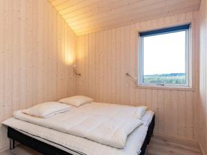 un letto in una stanza con una finestra di 5 star holiday home in Jerup a Bratten Strand