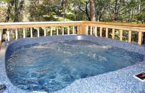 a hot tub in a garden with a wooden fence at Witt's End in Sevierville