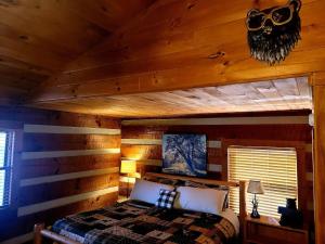 a bedroom with a bed in a log cabin at Witt's End in Sevierville +22 photos