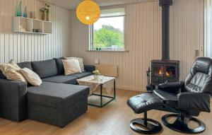a living room with a couch and a wood stove at Awesome Home In Farsø With Sauna in Farsø