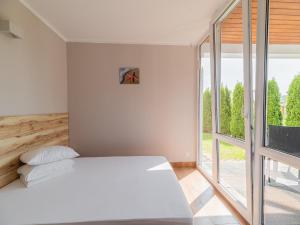 a bedroom with a white bed and a large window at Comfortable holiday homes near the sea, pool in Sianozety +25 photos