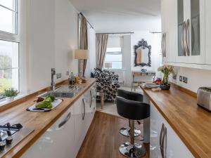 a white kitchen with a sink and a counter top at Babbacombe Bay, Torquay in Torquay +8 photos