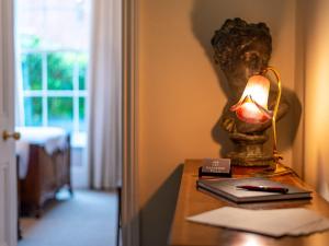 a lamp on a table with a bust on it at Langford Villa in Filey +6 photos