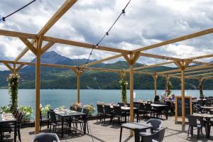 un patio con mesas y sillas y vistas al lago en Chorges Lakeside Stay with a Fireplace, en Grand PrÃ© 17 fotos más