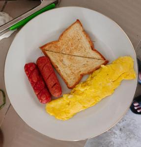 a plate of breakfast food with eggs sausage and toast at Ekas Elen Homestay in Pulau Gilkaliantan +16 photos