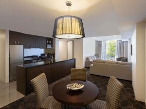 a living room and kitchen with a table and chairs at The Sebel Melbourne Kew in Melbourne
