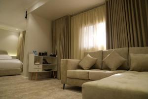una sala de estar con un sofá y una cama en نسيم الحرم, en Ash Shishah