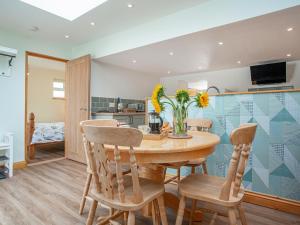 a kitchen and dining room with a wooden table and chairs at Trelawney Cottage in Charlestown