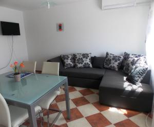 ein Wohnzimmer mit einem Sofa und einem Tisch in der Unterkunft Apartments Lalić in Vir