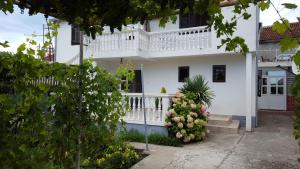 een wit huis met een balkon en bloemen bij Draskovic's House in Bar