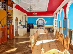 a large dining room with a long table and chairs at The Auction House in Criccieth