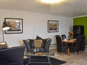 a living room with black chairs and a table and a dining room at The Calving Shed in Neilston