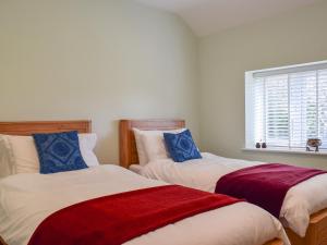two twin beds in a room with a window at Brooklands Farm Cottage in Biggleswade +9 photos
