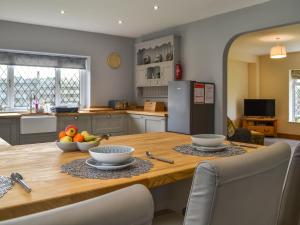 una cucina con tavolo in legno e ciotole di frutta di Heatherdene - Fern Cottage a Wilberfoss