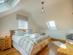 una camera da letto con un letto grande in una mansarda di Deri Cottage a Chwilog Altre 7 foto