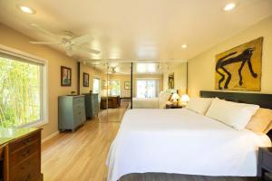 una camera da letto con un grande letto bianco e un bagno di Bay Area Garden Retreat a Rheem