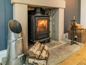 a fireplace in a living room with a stove at South Carolina Farm House in Tansley