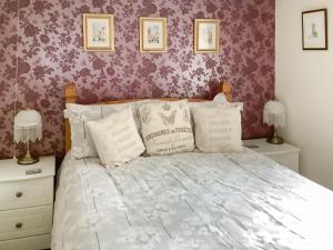 Schlafzimmer mit einem Bett mit lila Tapeten in der Unterkunft Bramley Lodge Annex in Clenchwarton