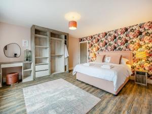 a bedroom with a bed and a floral wall at Cowslip Cottage - Uk47072 in Maltby le Marsh +19 photos